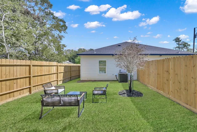 a view of a backyard with table and chairs and potted plants