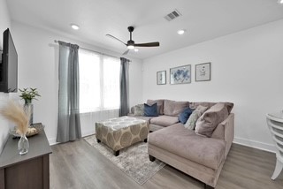 211 South 5th Street, Unit B Conroe, TX 77301 - Photo 3 of 14 a living room with furniture and a flat screen tv