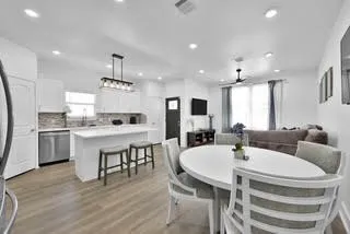 a kitchen with a dining table chairs stove microwave and cabinets