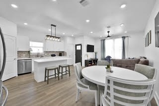 211 South 5th Street, Unit B Conroe, TX 77301 - Photo 4 of 14 a kitchen with a dining table chairs stove microwave and cabinets