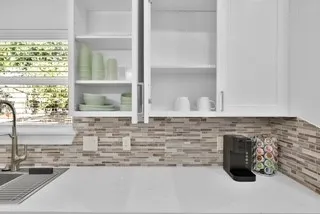 a bathroom with a granite countertop sink and a window