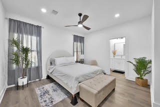 211 South 5th Street, Unit B Conroe, TX 77301 - Photo 7 of 14 a bedroom with a large bed and a chandelier