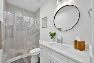 a bathroom with a granite countertop sink a toilet and a mirror