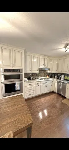 a spacious bedroom with a bed and a dresser