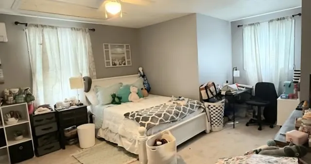 a bedroom with a bed window and dresser