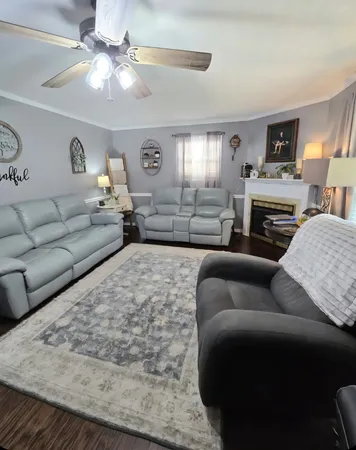 a living room with furniture fireplace and a window