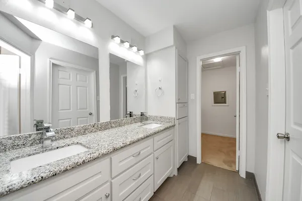 a bathroom with a granite countertop sink and a mirror
