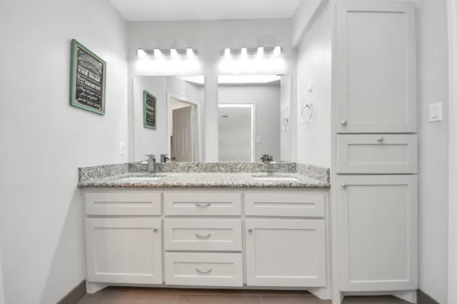 a bathroom with a sink vanity and mirror