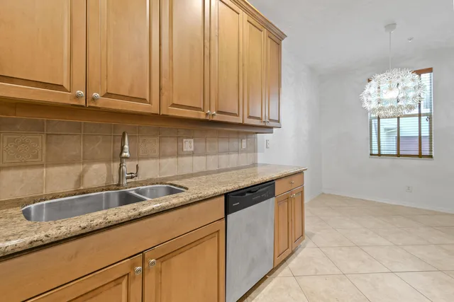 a kitchen with granite countertop a sink and a white cabinets