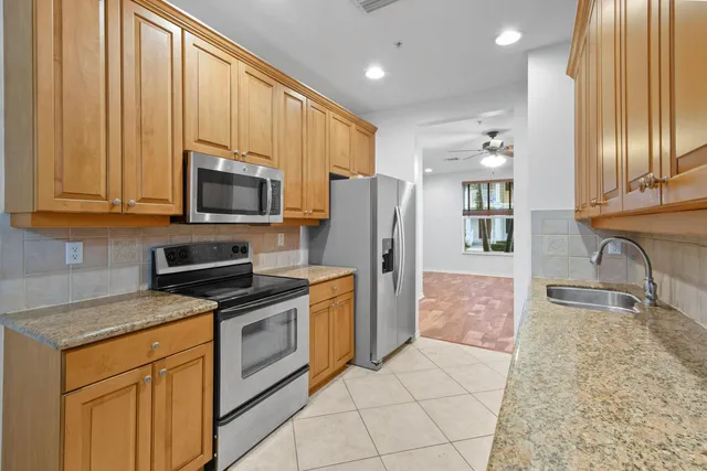 a kitchen with stainless steel appliances granite countertop a refrigerator stove and sink