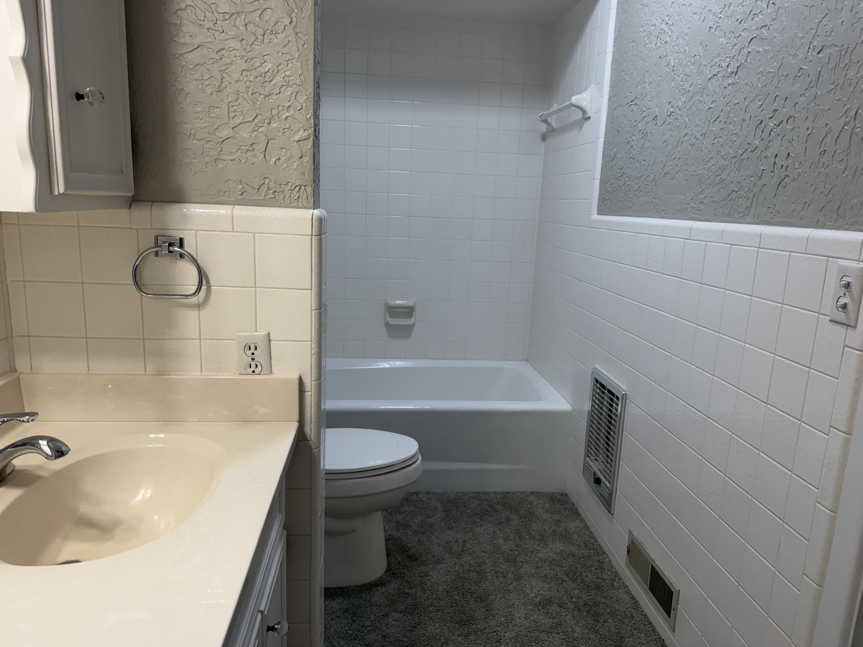 1603 South 8th Street Lamesa, TX 79331 - Photo 14 of 39 a bathroom with a sink a toilet and bathtub