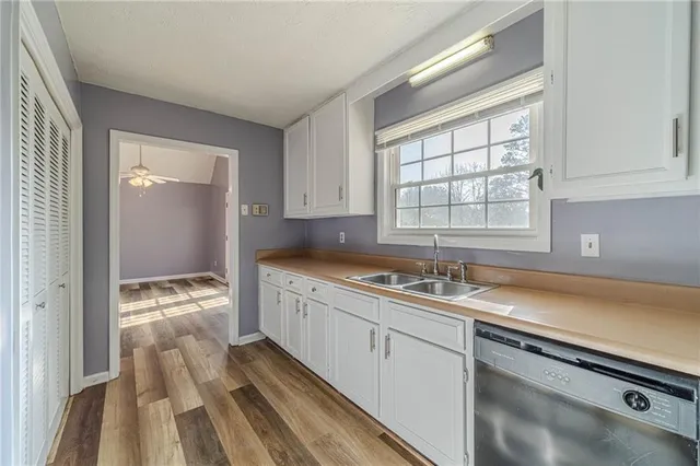 a kitchen with stainless steel appliances granite countertop a lot of counter space and wooden floors