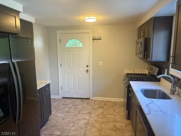 a kitchen that has a sink a refrigerator and cabinets