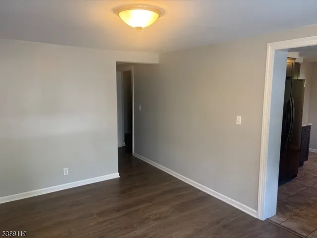 an empty room with wooden floor and closet
