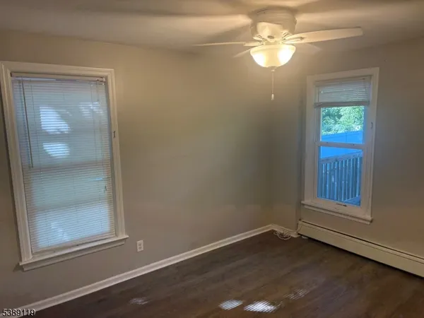 an empty room with windows and fan