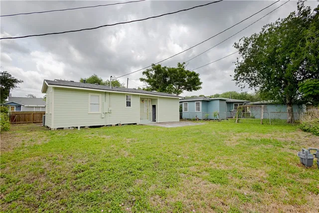 a view of a backyard with plants and large trees