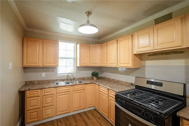 a kitchen with granite countertop wooden cabinets stove top oven and sink