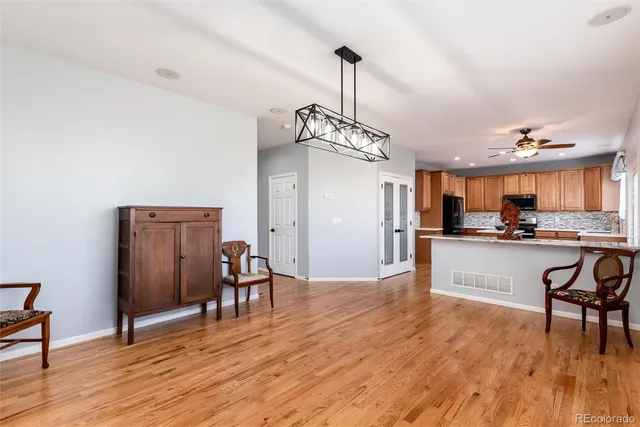 a view of a dining room and livingroom with furniture wooden floor a chandelier