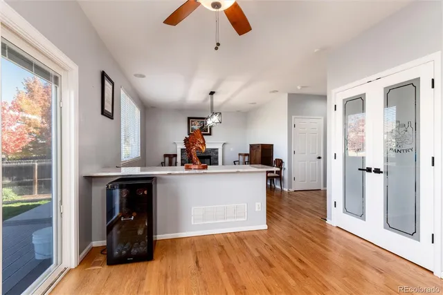 a living room with stainless steel appliances kitchen island granite countertop furniture a large window and wooden floors