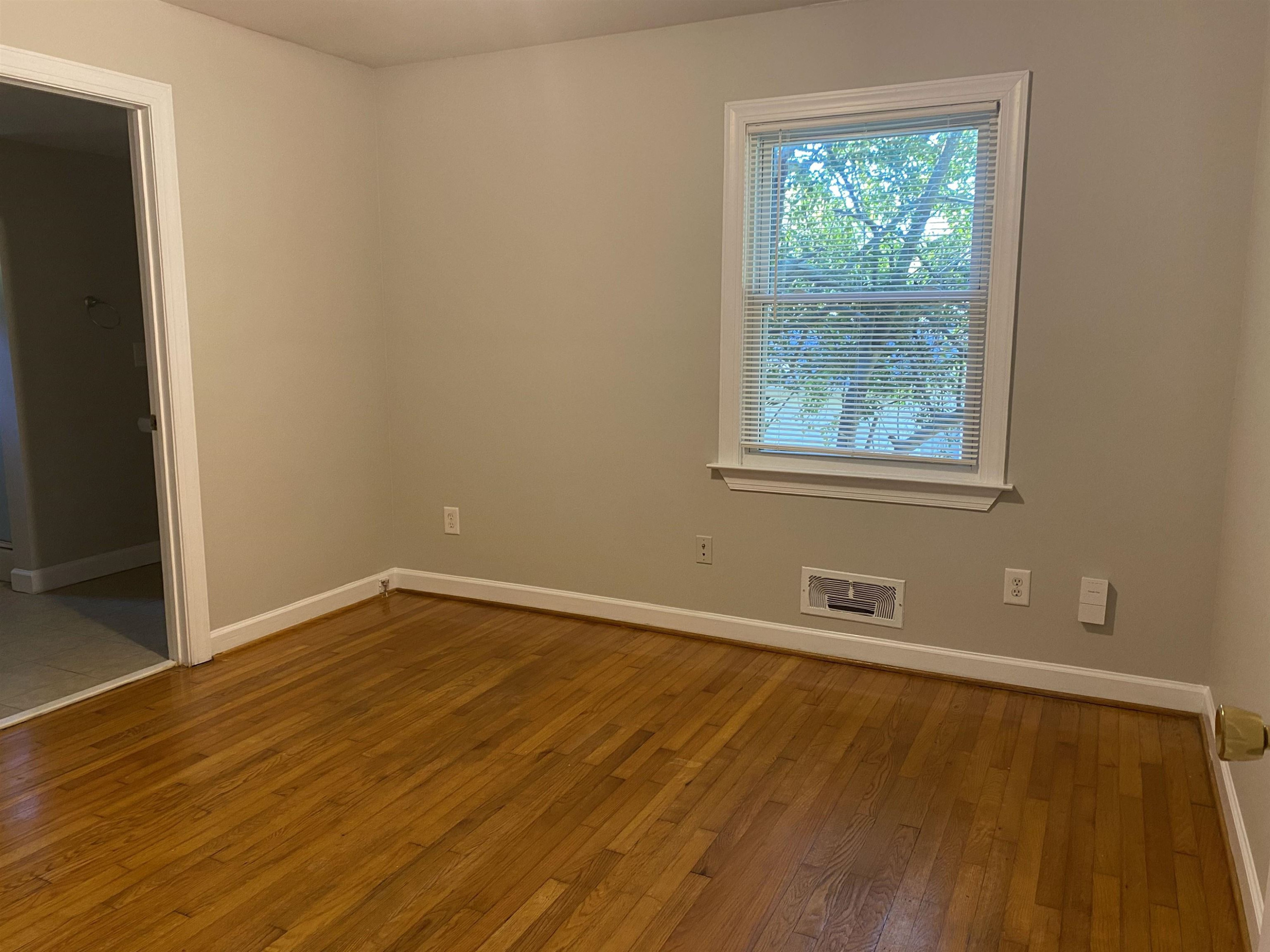 633 Buck Jones Road Raleigh, NC 27606 - Photo 11 of 20 an empty room with wooden floor and windows