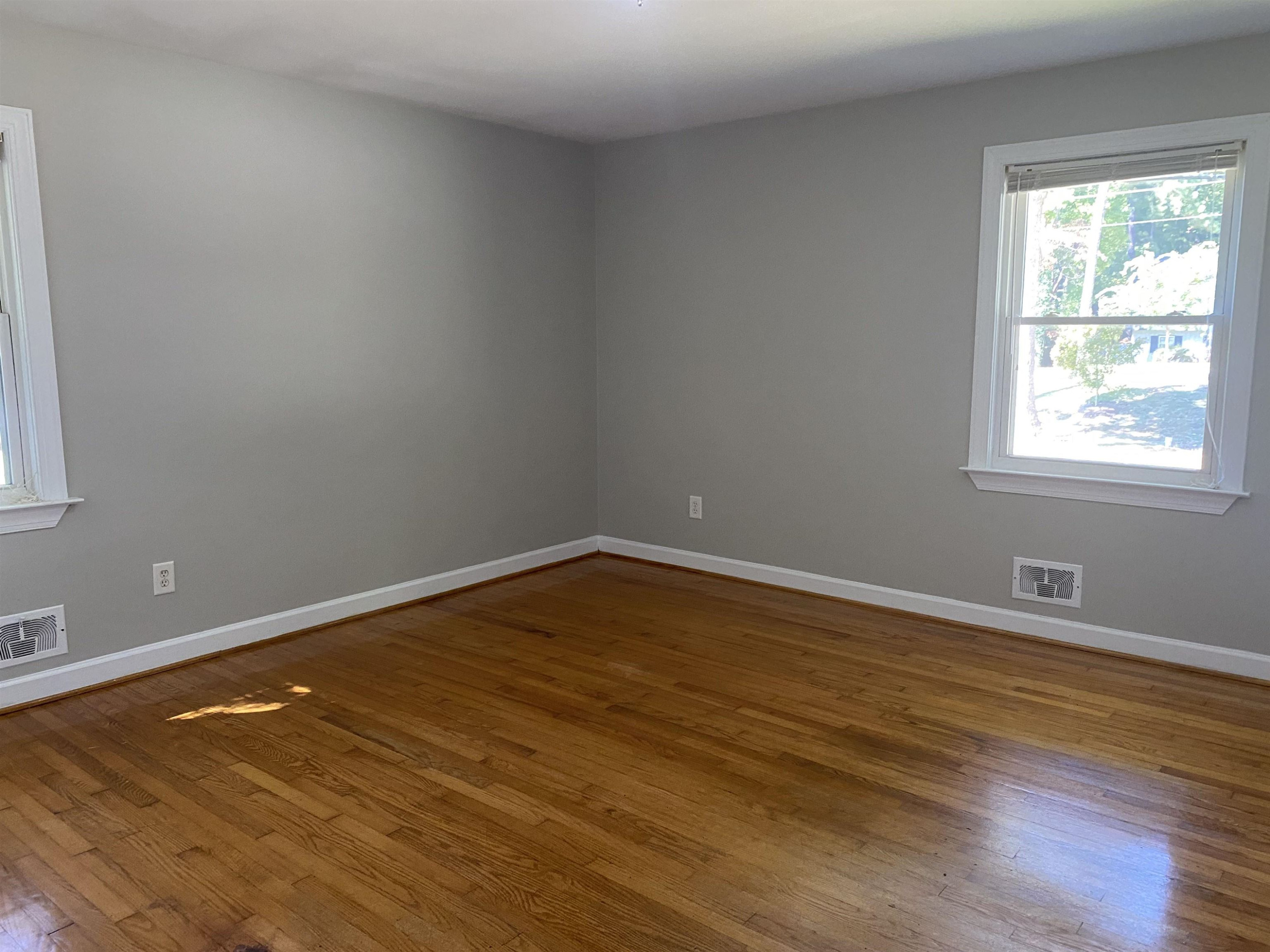 633 Buck Jones Road Raleigh, NC 27606 - Photo 10 of 20 a view of an empty room with wooden floor and a window