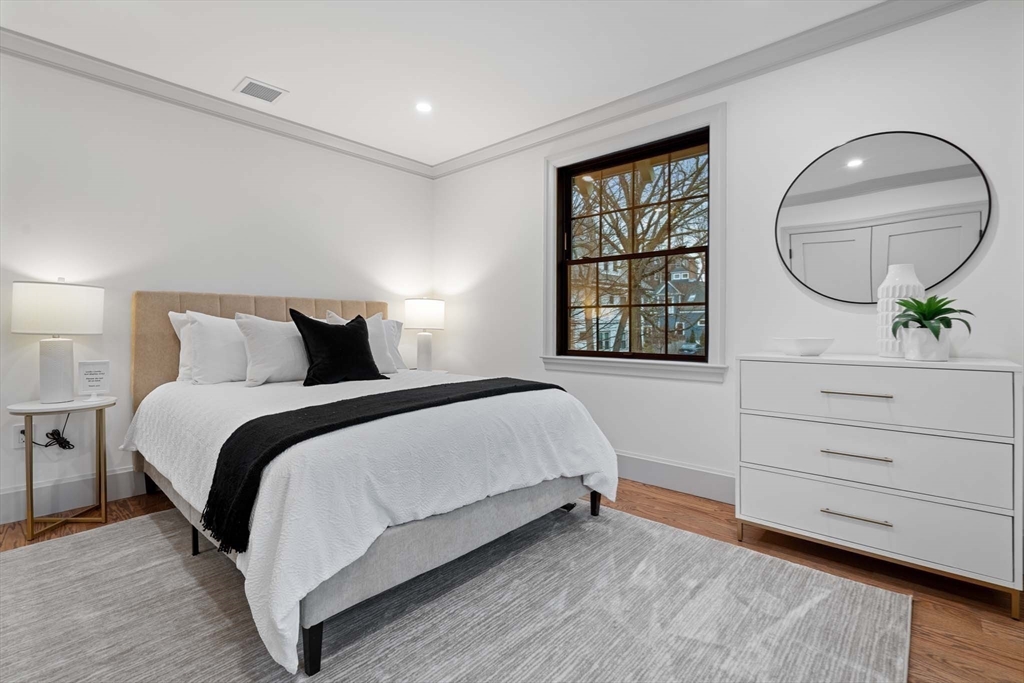 8 Stetson Street Brookline, MA 02446 - Photo 18 of 36 a bedroom with a large bed and a mirror