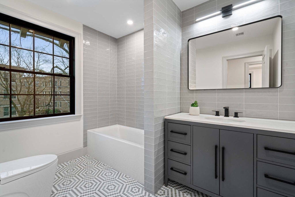 8 Stetson Street Brookline, MA 02446 - Photo 19 of 36 a bathroom with a bathtub sink vanity mirror and toilet