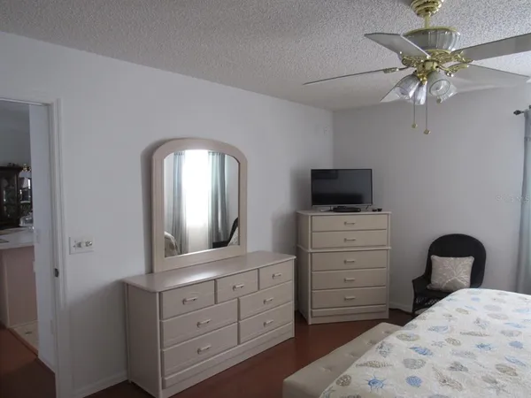 a bedroom with a bed and a mirror on dresser