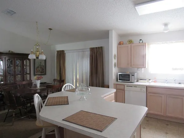 a kitchen with a table chairs sink and cabinets