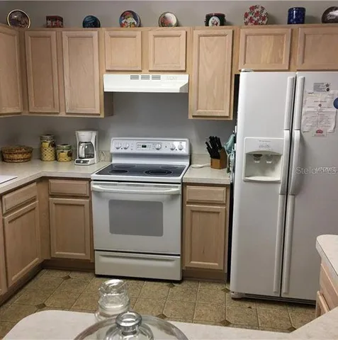 a kitchen with stainless steel appliances a stove a refrigerator a sink and cabinets