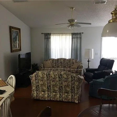 a living room with furniture a chandelier and a window