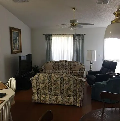 a living room with furniture a chandelier and a window