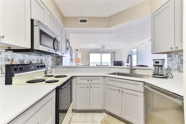 a kitchen with white cabinets and white appliances