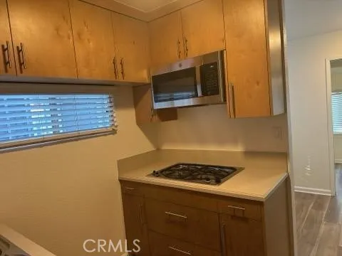 a kitchen with a sink a microwave and cabinets