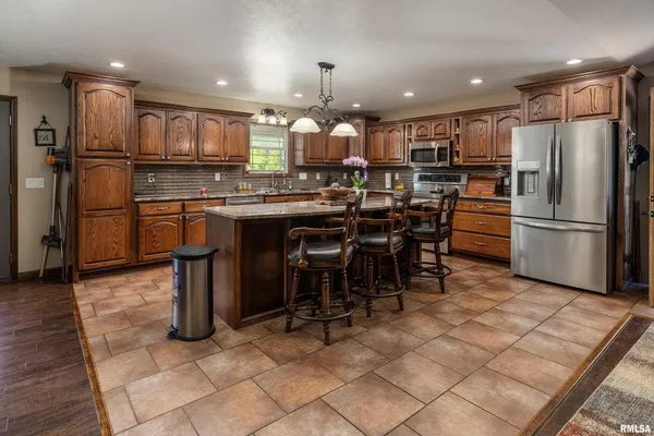 a kitchen with refrigerator and chairs