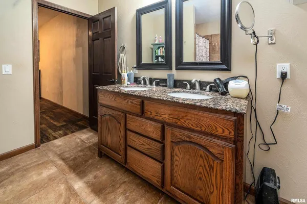 a bathroom with a granite countertop sink and a mirror