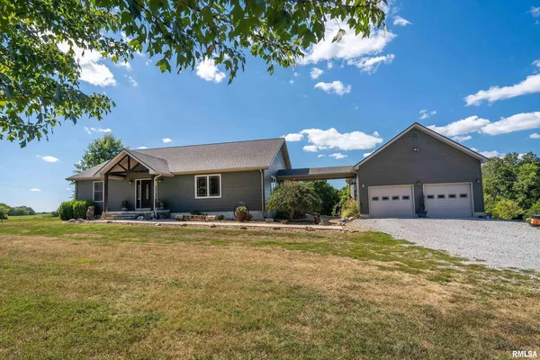 a front view of house with yard and trees in the background
