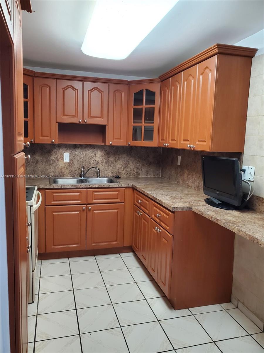 14250 Southwest 62nd Street, Unit 505 Miami, FL 33183 - Photo 11 of 38 a kitchen with stainless steel appliances granite countertop a stove a sink and a microwave