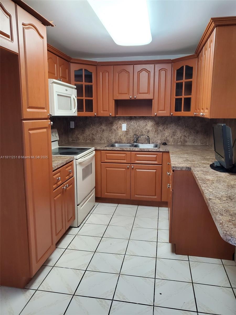 14250 Southwest 62nd Street, Unit 505 Miami, FL 33183 - Photo 12 of 38 a kitchen with stainless steel appliances granite countertop a stove a sink and a microwave