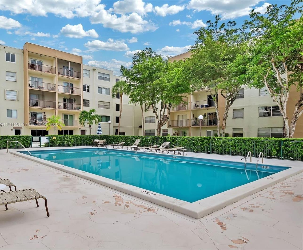14250 Southwest 62nd Street, Unit 505 Miami, FL 33183 - Photo 27 of 38 a view of a house with a swimming pool and a yard