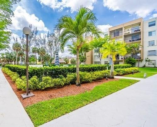 14250 Southwest 62nd Street, Unit 505 Miami, FL 33183 - Photo 29 of 38 a view of a garden with a building in the background