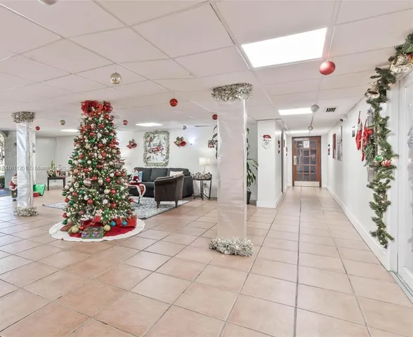a room with lots of white furniture and potted plants