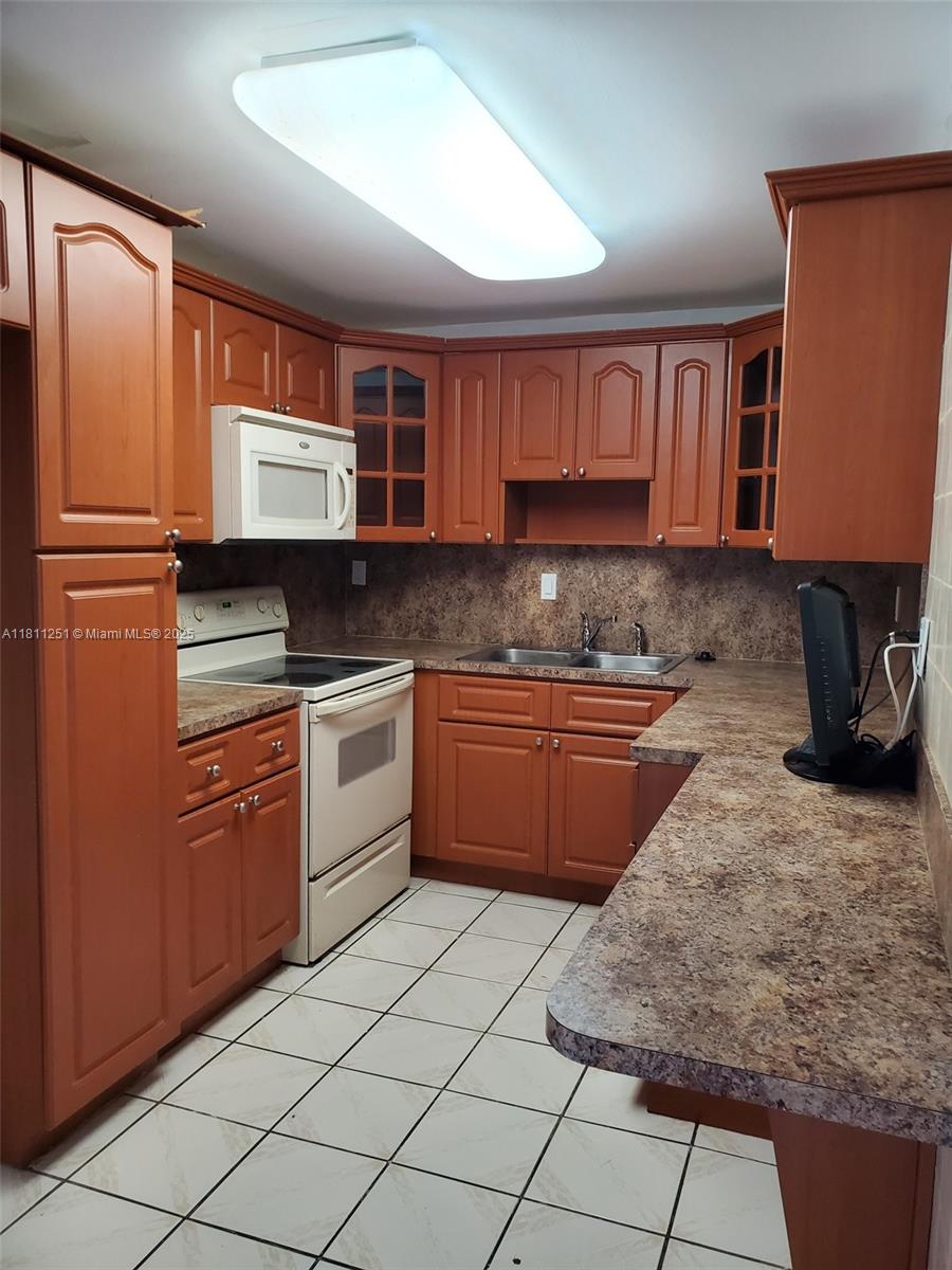 14250 Southwest 62nd Street, Unit 505 Miami, FL 33183 - Photo 10 of 38 a kitchen with stainless steel appliances granite countertop a sink stove refrigerator and cabinets