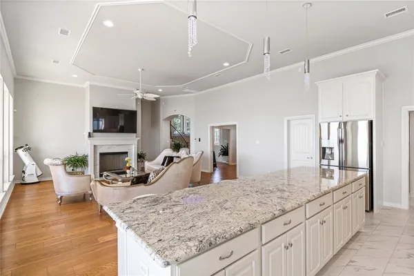 a dining hall with stainless steel appliances kitchen island granite countertop a dining table chairs and view living room