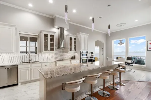 a dining room with furniture a large window and a chandelier