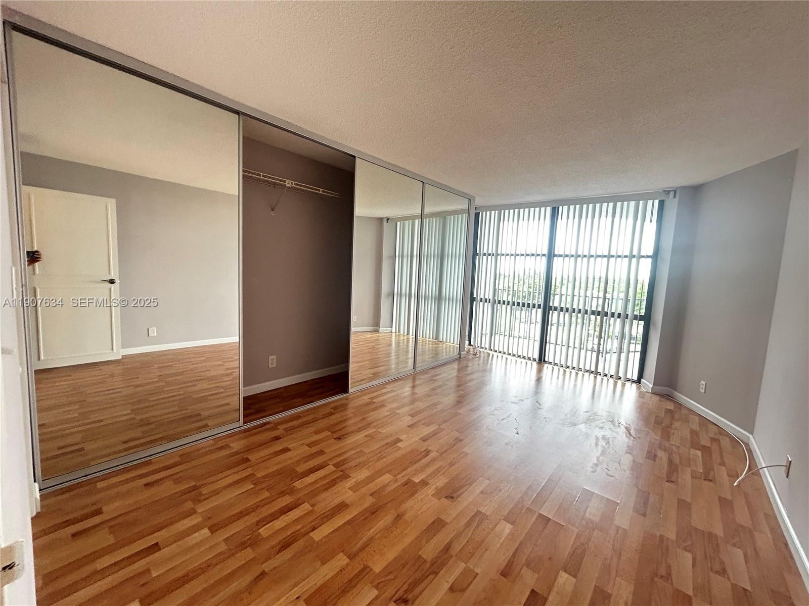 1000 Parkview Drive, Unit 511 Hallandale Beach, FL 33009 - Photo 4 of 17 a view of an empty room with wooden floor and a window