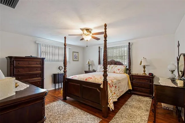 a bedroom with a bed and dresser with mirror