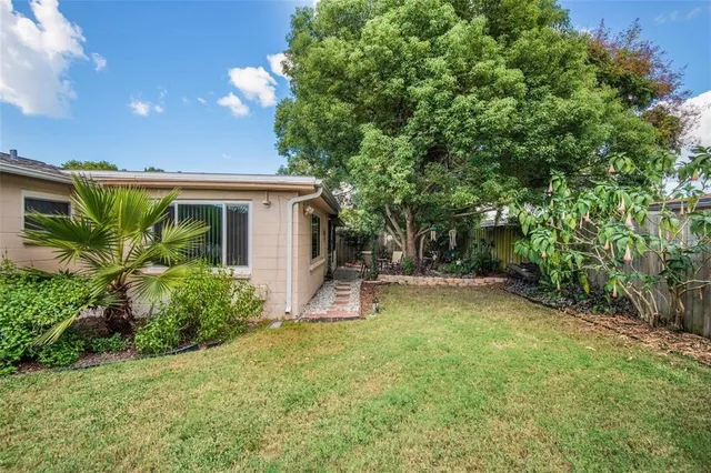 a view of a house with backyard and sitting area