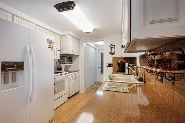 a kitchen with stainless steel appliances kitchen island granite countertop a refrigerator and a stove top oven