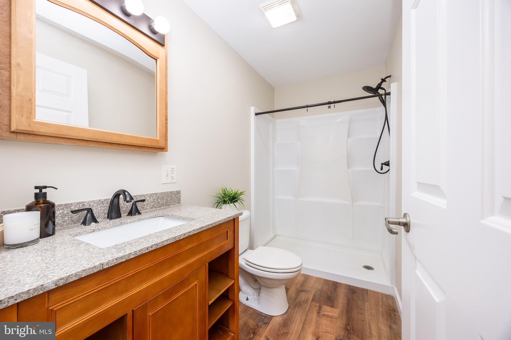 6635 Libertytown Road Berlin, MD 21811 - Photo 40 of 88 a bathroom with a granite countertop sink toilet and shower
